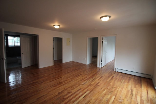 unfurnished room with a baseboard radiator and light hardwood / wood-style flooring