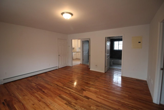 interior space with dark hardwood / wood-style flooring, ensuite bath, electric panel, and baseboard heating