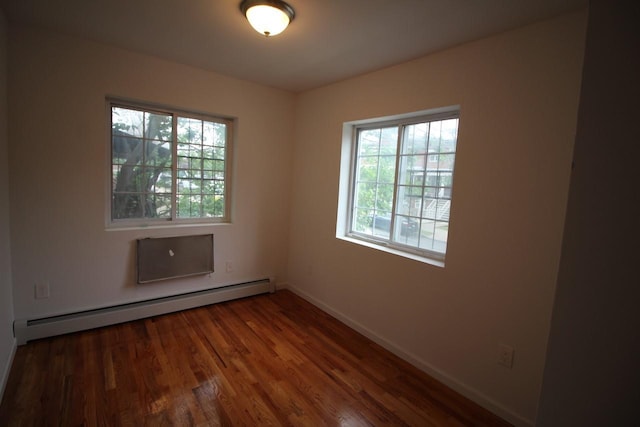 empty room featuring dark hardwood / wood-style flooring and baseboard heating