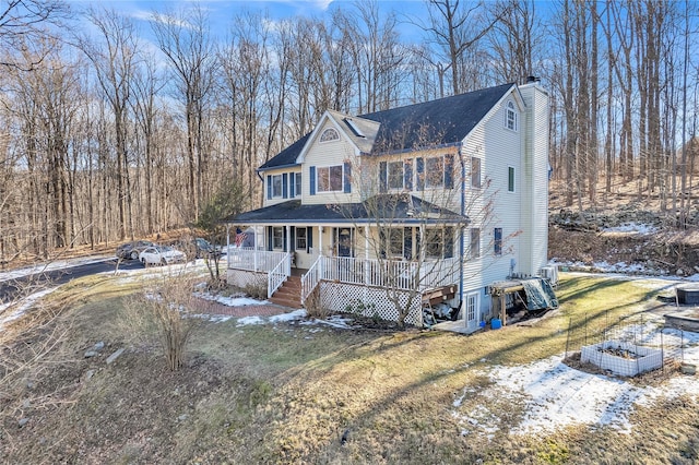 farmhouse-style home with a porch and a lawn