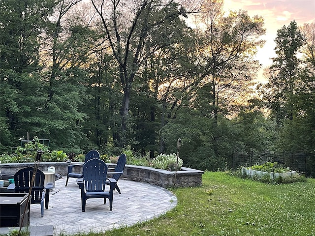 patio terrace at dusk featuring a yard