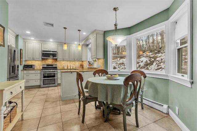 dining space featuring light tile patterned flooring and baseboard heating