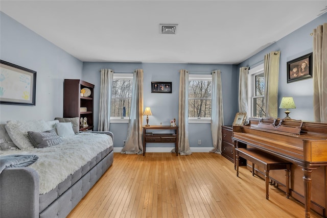 bedroom featuring multiple windows and light hardwood / wood-style floors