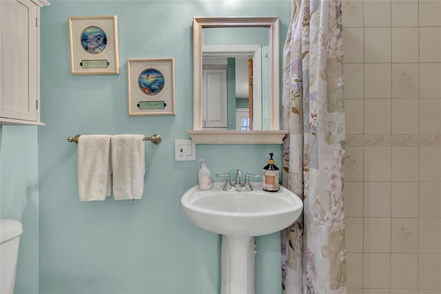 bathroom with sink, toilet, and a shower with shower curtain