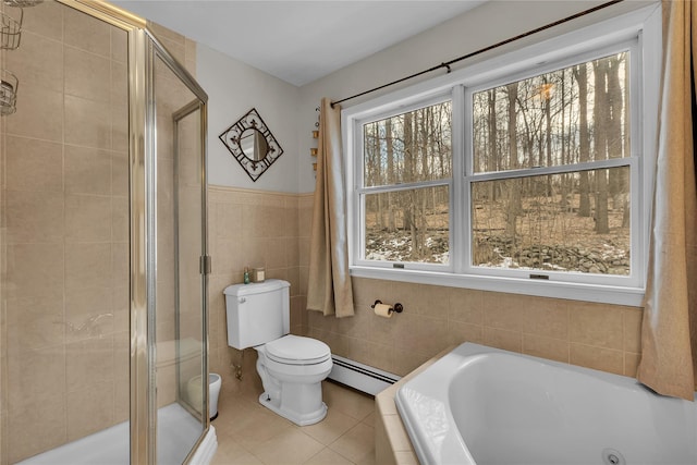 bathroom with tile walls, tile patterned flooring, separate shower and tub, baseboard heating, and toilet