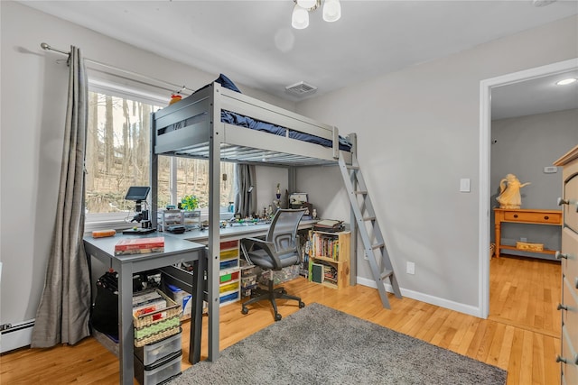 bedroom featuring hardwood / wood-style floors and baseboard heating