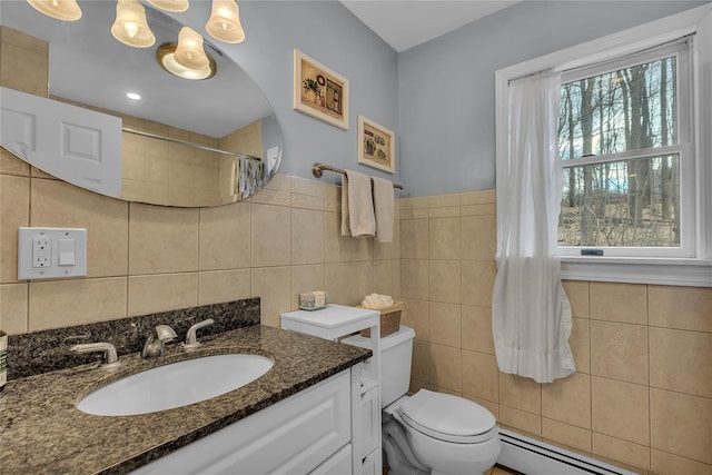 bathroom featuring toilet, tile walls, baseboard heating, vanity, and curtained shower