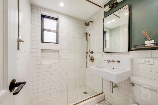 bathroom featuring a tile shower, sink, tile walls, backsplash, and toilet