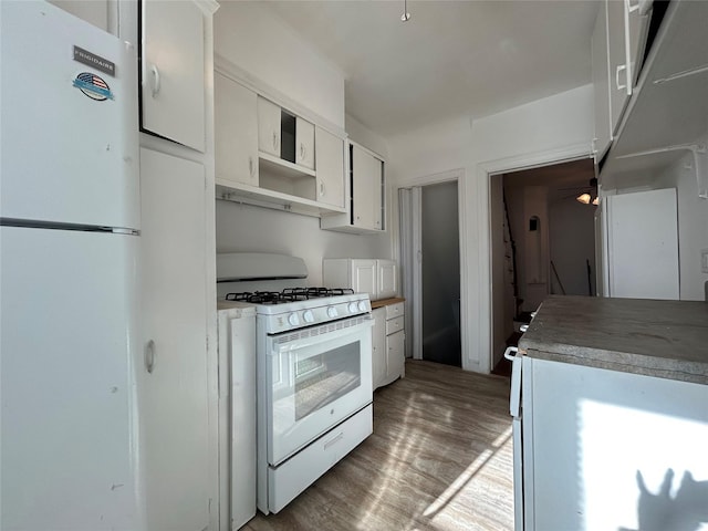 kitchen with wood-type flooring, white cabinets, and white appliances