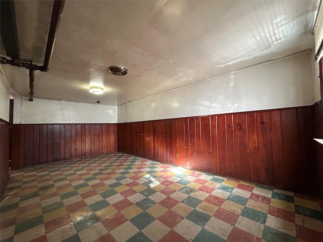 basement featuring wood walls