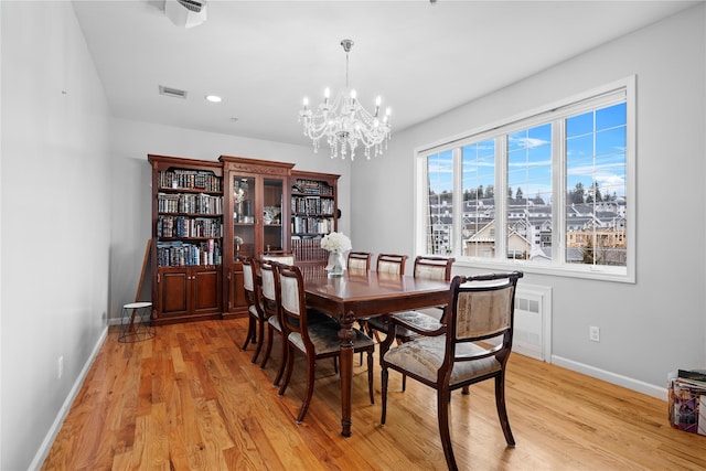 dining room with an inviting chandelier and light hardwood / wood-style flooring