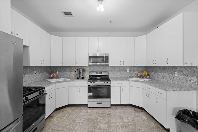 kitchen featuring tasteful backsplash, stainless steel appliances, sink, and white cabinets