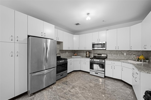 kitchen with stainless steel appliances, sink, and white cabinets