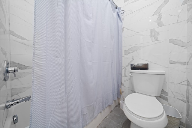 bathroom featuring tile patterned floors, toilet, curtained shower, and tile walls