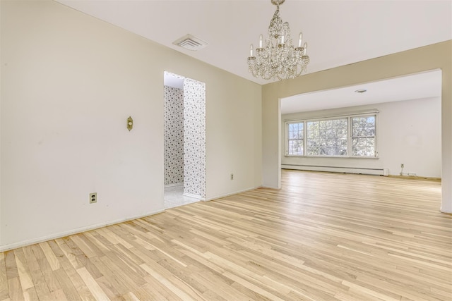 unfurnished living room featuring an inviting chandelier, a baseboard heating unit, and light hardwood / wood-style floors