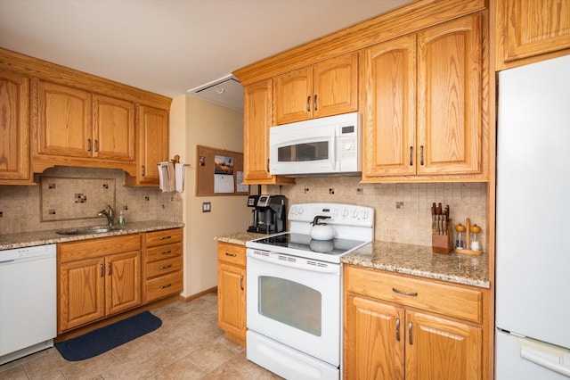 kitchen with tasteful backsplash, sink, white appliances, and light stone countertops