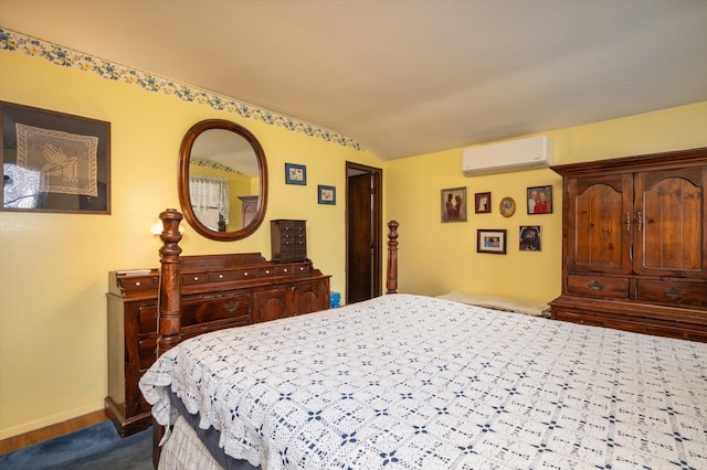 bedroom featuring an AC wall unit and lofted ceiling