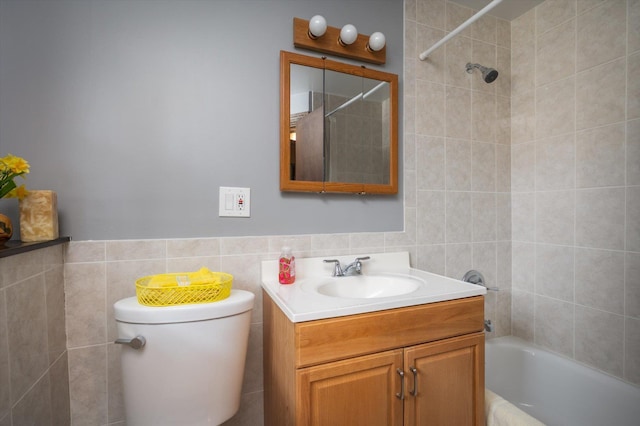 full bathroom with tiled shower / bath, vanity, toilet, and tile walls