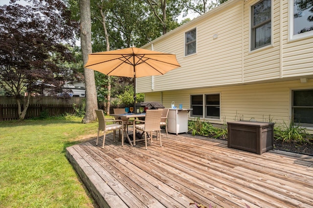 wooden deck with grilling area and a lawn