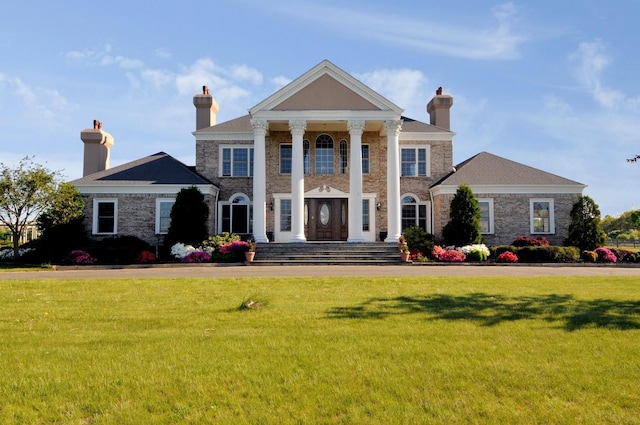 greek revival house featuring a front yard