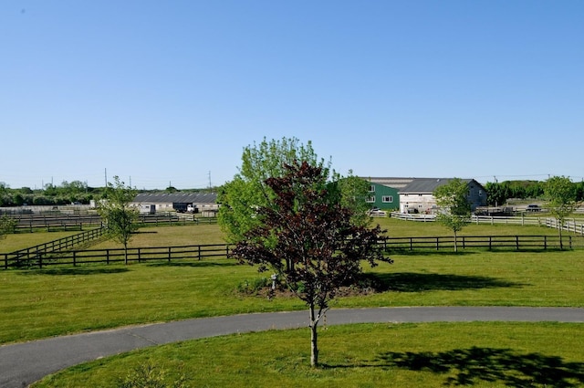 view of property's community with a lawn and a rural view