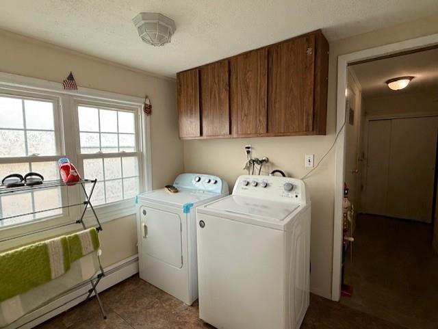 washroom with cabinets, a baseboard heating unit, and washing machine and clothes dryer