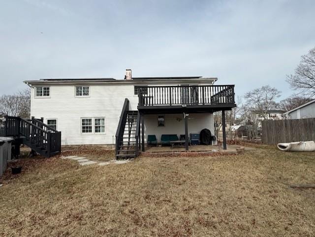 rear view of house with a wooden deck and a yard