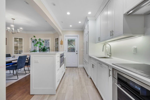 kitchen featuring white cabinetry, sink, light hardwood / wood-style flooring, and stainless steel oven