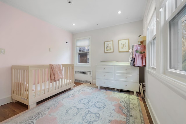 bedroom featuring hardwood / wood-style flooring and radiator heating unit