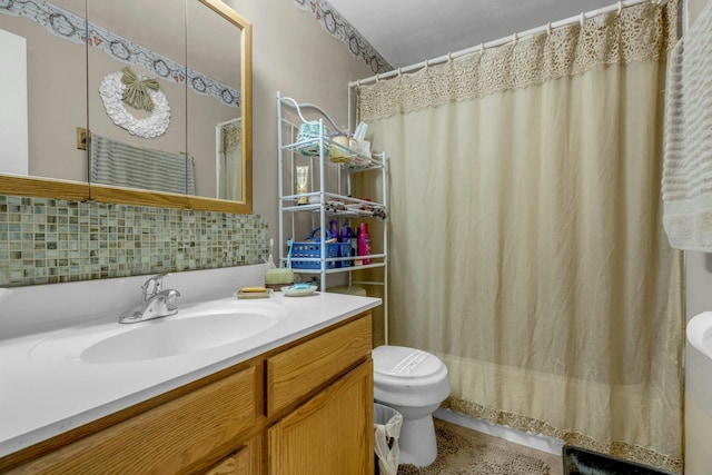 full bathroom featuring vanity, backsplash, toilet, and shower / bath combo with shower curtain