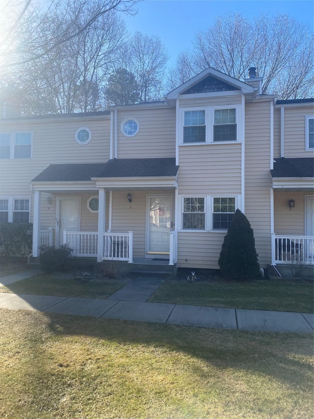 view of property featuring a porch and a front yard