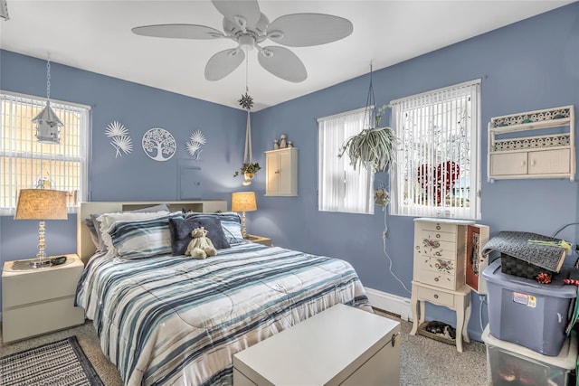 carpeted bedroom with ceiling fan and multiple windows