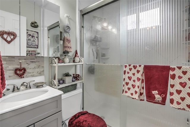 bathroom with a shower with door, vanity, and toilet