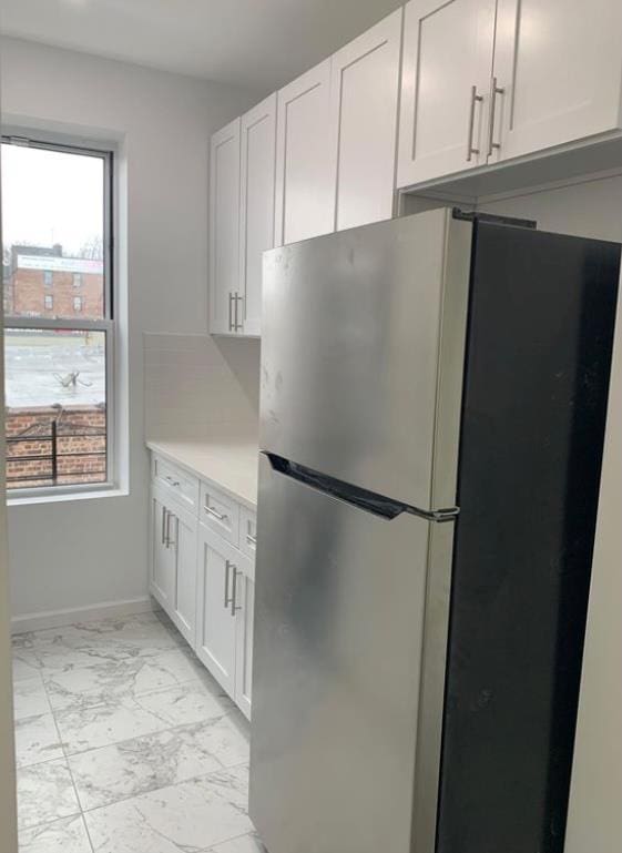 kitchen with white cabinetry and stainless steel refrigerator