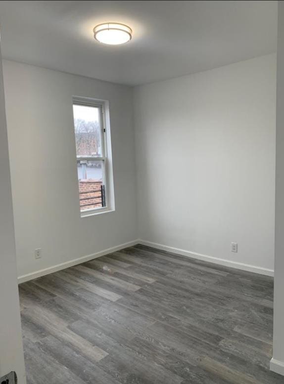 spare room with dark wood-type flooring