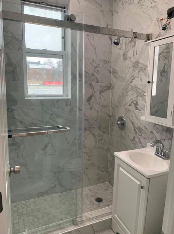 bathroom featuring walk in shower and vanity