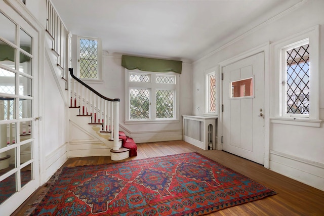 entrance foyer with hardwood / wood-style floors and radiator heating unit