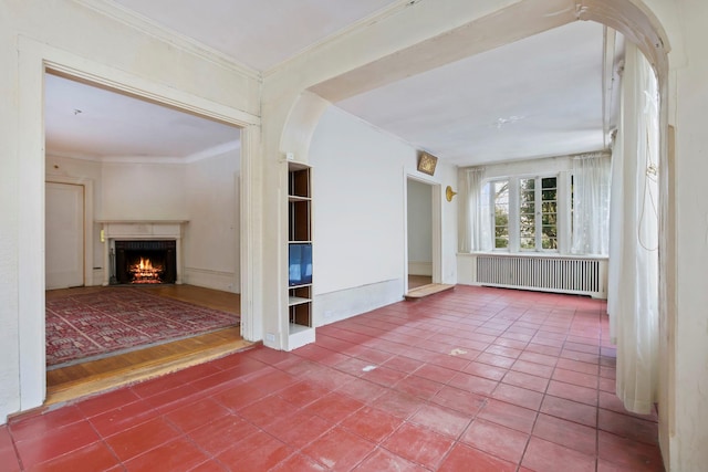 interior space featuring tile patterned flooring, ornamental molding, and radiator heating unit