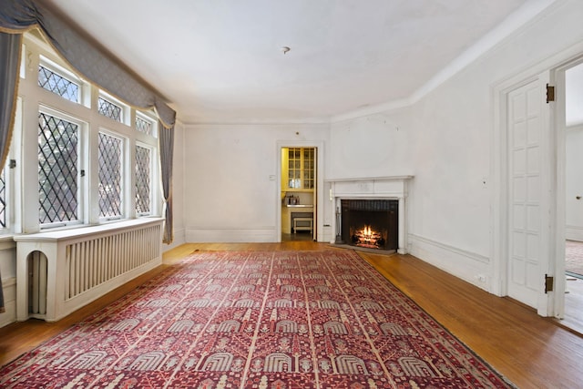 unfurnished living room with hardwood / wood-style floors and a brick fireplace