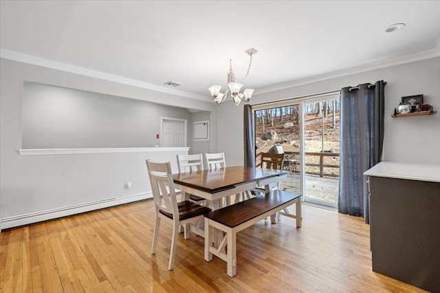 dining area featuring light wood-style flooring, a baseboard heating unit, a chandelier, and ornamental molding