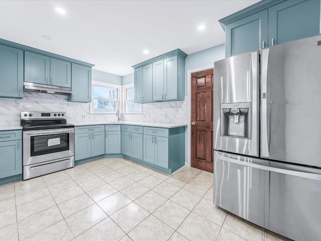 kitchen with sink, blue cabinetry, appliances with stainless steel finishes, light tile patterned flooring, and decorative backsplash