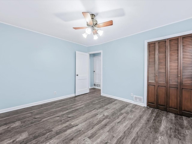 unfurnished bedroom featuring hardwood / wood-style floors, ceiling fan, and a closet