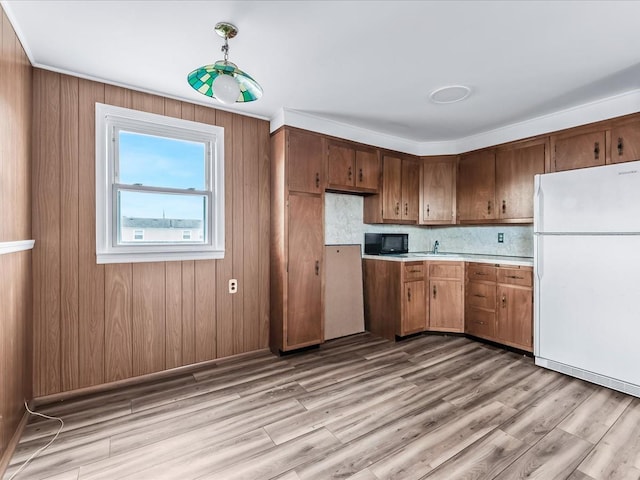 kitchen featuring backsplash, light wood-type flooring, sink, and white refrigerator