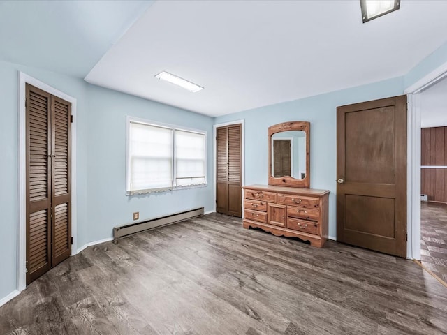 unfurnished bedroom featuring a baseboard radiator and dark hardwood / wood-style floors