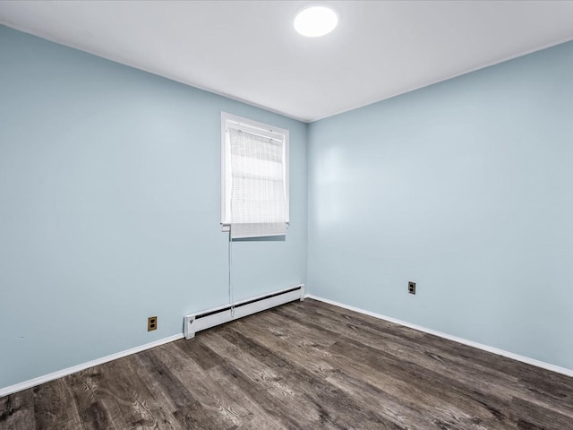 spare room featuring a baseboard radiator and dark wood-type flooring