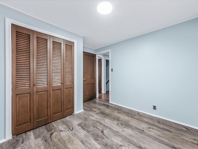 unfurnished bedroom with light wood-type flooring and a closet