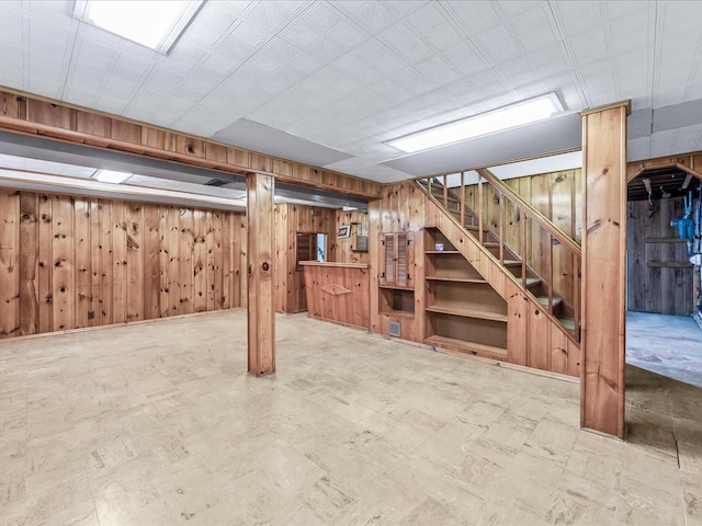 basement featuring wooden walls