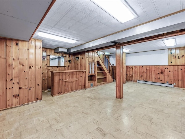 basement with bar, wooden walls, and baseboard heating