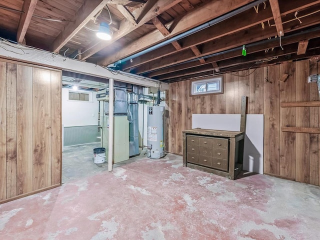 basement featuring wooden walls and water heater