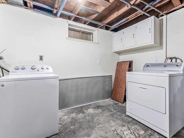 clothes washing area featuring washer and dryer and cabinets